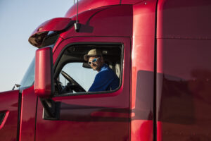 USA,Truck driver, man in a red lorry cab.